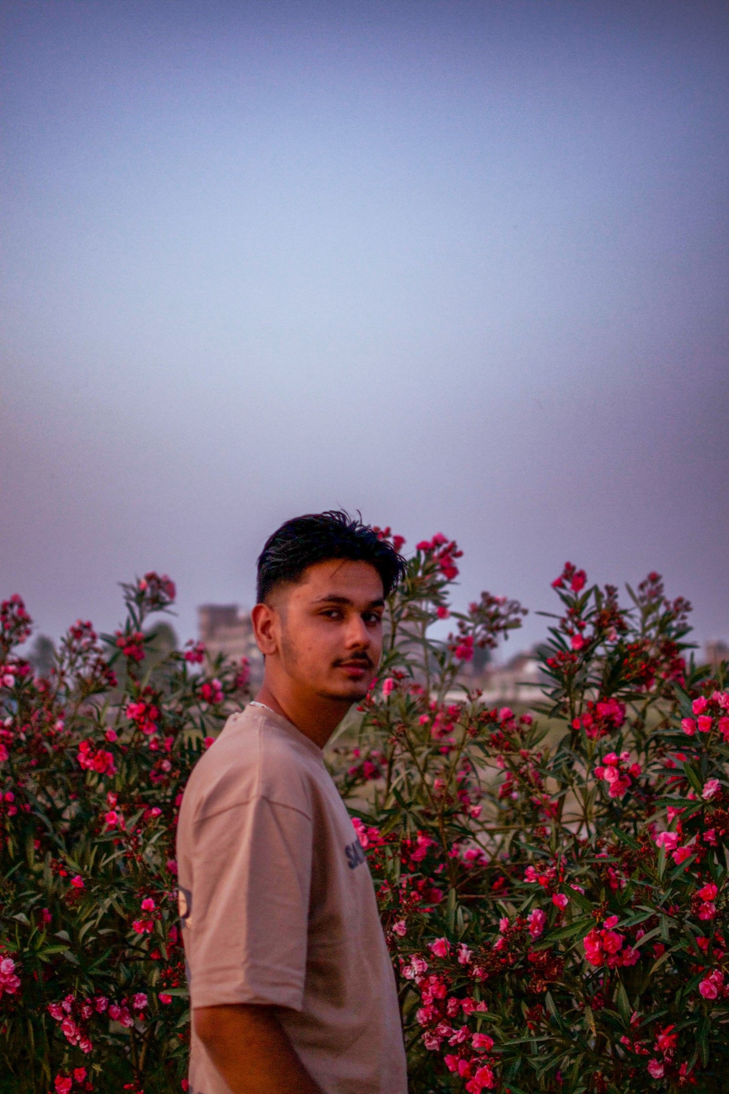 Sanchit Gogna framed by flowering shrubs